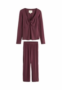 Top burdeos de manga larga con detalle de torsión en el escote, combinado con pantalones de cintura elástica a juego, fabricados con tejido suave.
