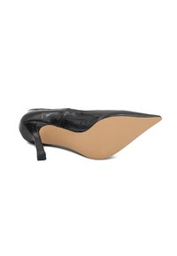 Scarpa con tacco alto in vernice nera, dalla punta affusolata e dal design elegante, con suola beige e tacco quadrato.