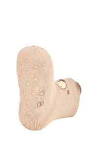 Beige gestrickte Socke mit einer strukturierten Sohle und Pfotenabdruckmustern. Hellbraune Akzente im Zehenbereich und ein gemütliches Design.