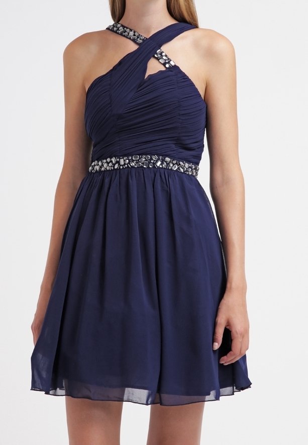 Marinblå cocktailklänning med en rynkad bodice, korsade band och en paljetterad midja. Utsåld kjol med ett lätt genomskinligt överlägg.
