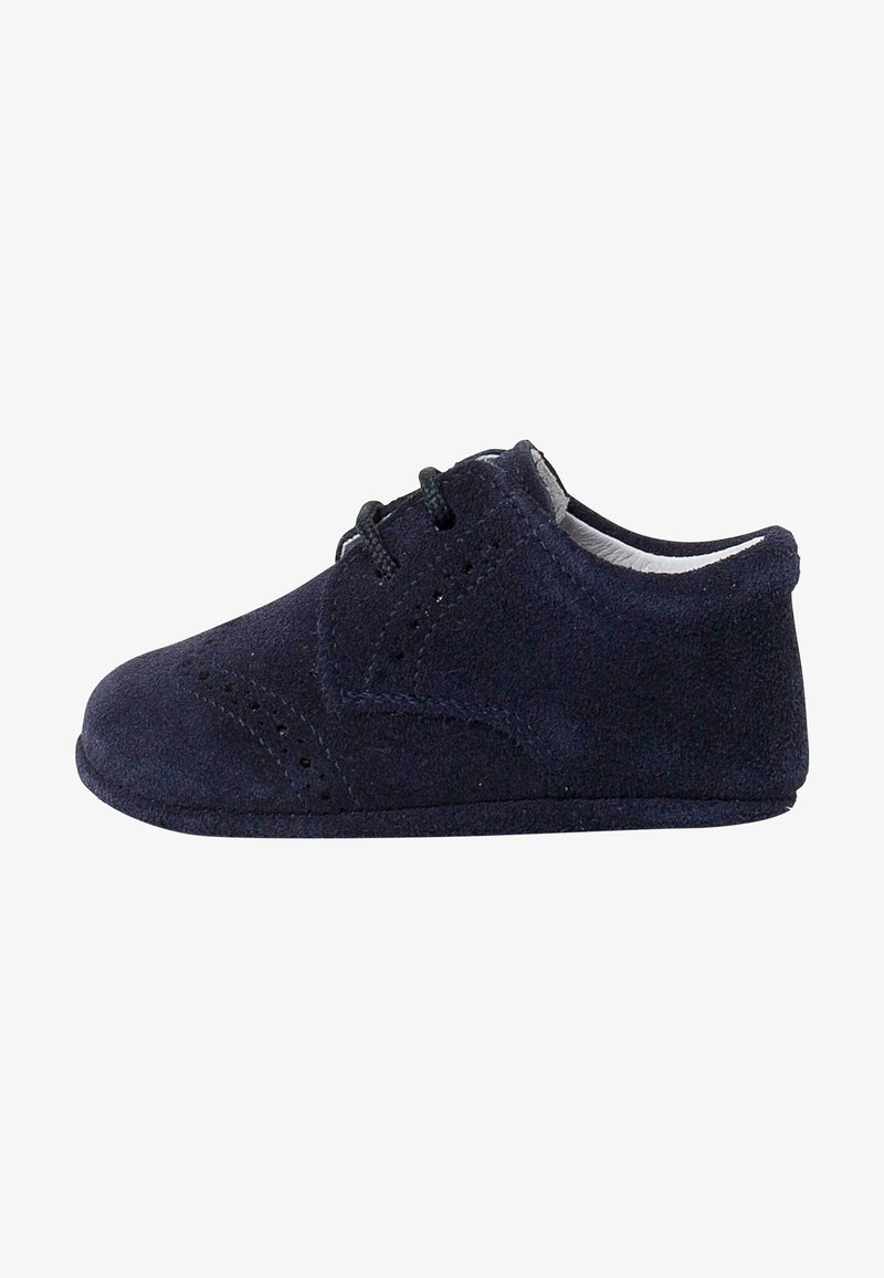 Chaussure bébé en daim bleu foncé avec lacets à l'avant, perforations style brogue et semelle souple, vue de profil sur fond blanc.