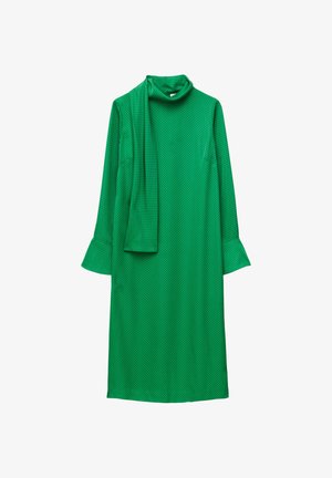 Green dress with a mock turtleneck, long sleeves, and flared cuffs. Features a textured fabric with a dotted pattern and a matching scarf.