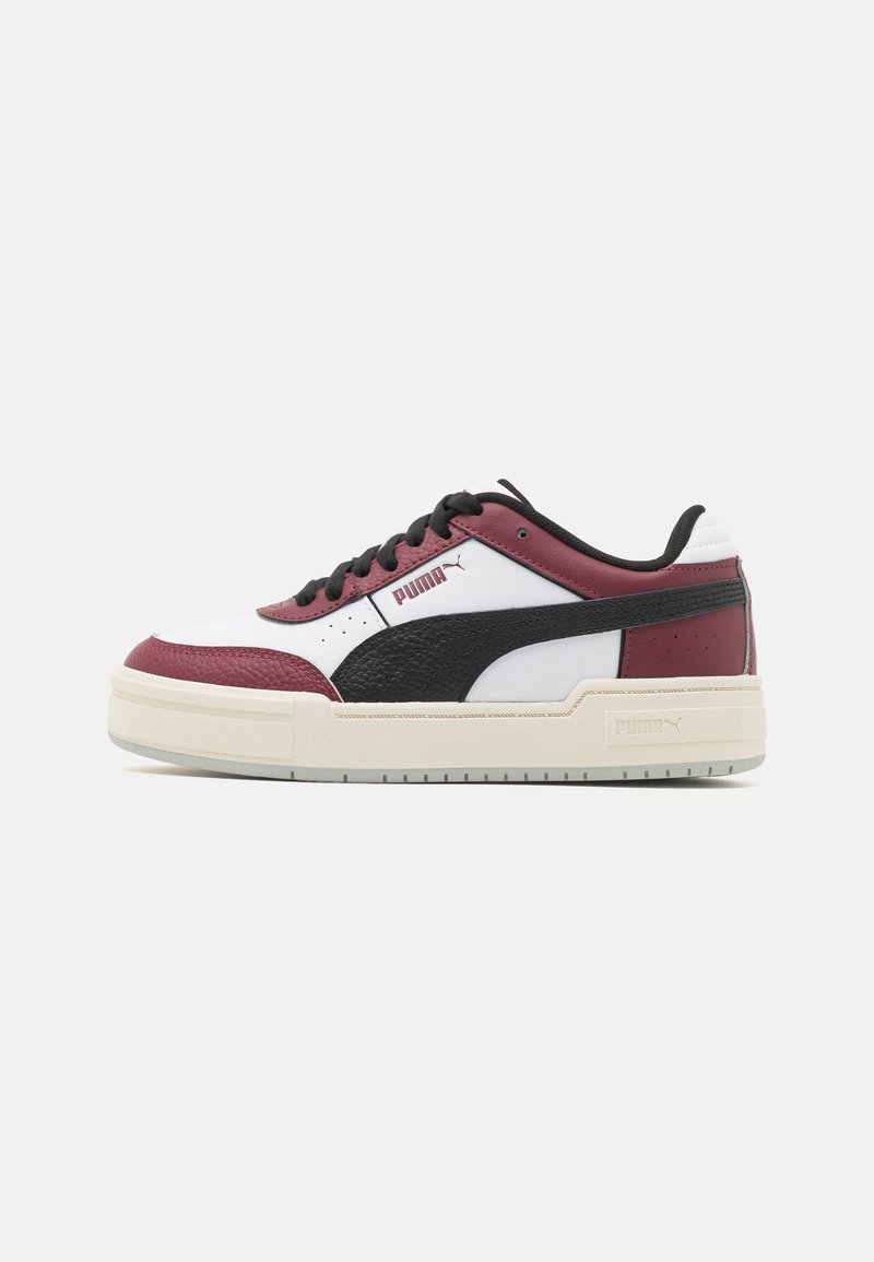 Le sneakers PUMA presentano una punta in pelle bianca, dettagli in pelle bordeaux e nera, una suola in gomma beige spessa e lacci neri. Logo sul lato.