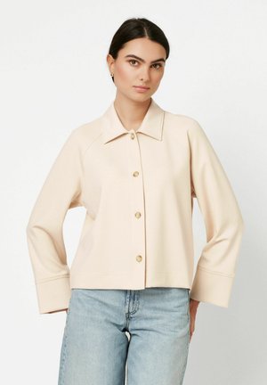 Cremefarbene, kurz geschnittene Jacke mit Kragen, fünf Knöpfen und weiten Ärmeln. Hergestellt aus weichem Stoff mit glatter Textur.