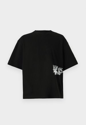 T-shirt oversize nera in cotone; presenta una stampa di testo e grafica bianca sul lato sinistro vicino all'orlo. Maniche corte e collo rotondo.