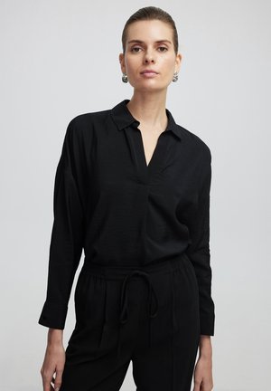 Black long-sleeve shirt with a collar and a partial placket, made from lightweight fabric; paired with matching black drawstring pants.