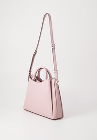 Borsa sintetica rosa con una forma strutturata, due manici e una tracolla staccabile. Presenta una texture liscia e hardware minimal.