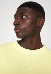 Karl Kani SMALL SIGNATURE WASHED CREW UNISEX - Sportska majica - light yellow
