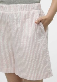 Roze en witte gestreepte shorts van lichtgewicht stof, met een zachte elastische tailleband en zijzakken. Subtiele textuur zichtbaar.