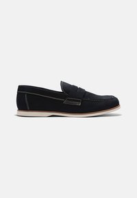 Mocasines azul oscuro hechos de cuero suave con costuras blancas, suela plana y una tira decorativa en el empeine. Diseño simple y minimalista.