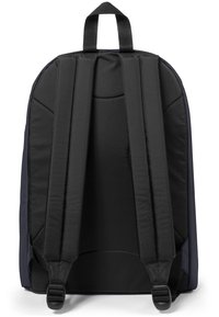Sac à dos noir avec des bretelles ajustables rembourrées, un extérieur en tissu texturé, une poignée supérieure et un design épuré sans matériel visible.