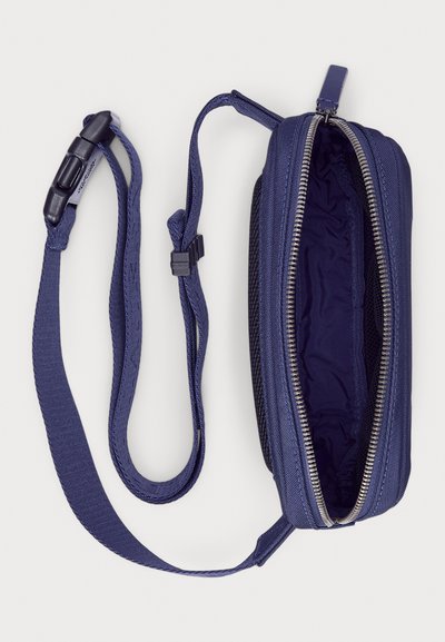 Navy blue zippered bag with a textured fabric and detachable strap. Lined interior features a single compartment and smooth zipper hardware.