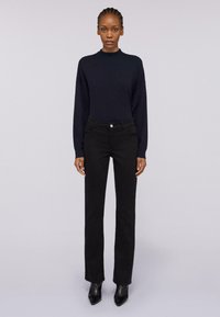 Námořnický dlouhý rukáv, černé přil�éhavé džíny a elegantní černé kožené boty na podpatku. Měkká textura a přizpůsobený střih s minimalistickým designem.