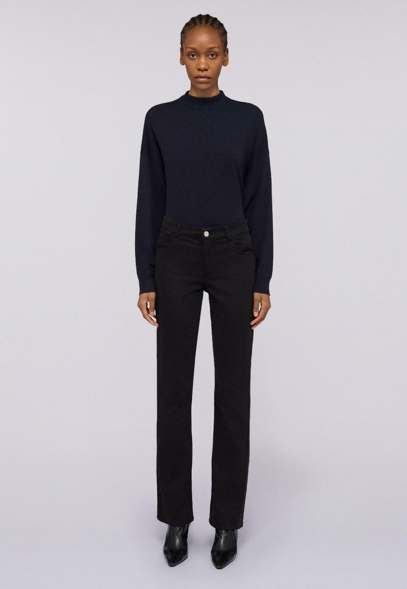 Námořnický dlouhý rukáv, černé přiléhavé džíny a elegantní černé kožené boty na podpatku. Měkká textura a přizpůsobený střih s minimalistickým designem.