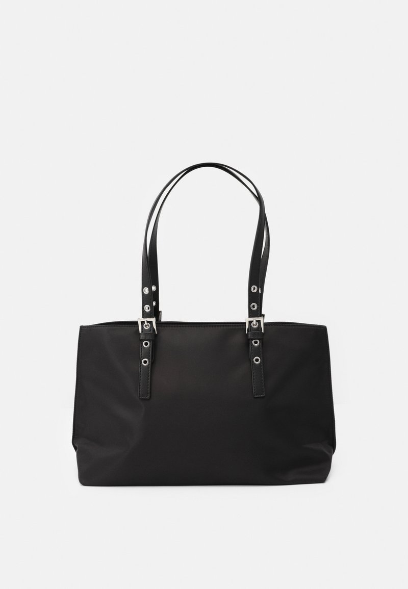 Sac fourre-tout rectangulaire noir avec double sangle en cuir présentant des détails de boucle et d'œillet argentés sur un fond uni.