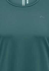 Κοντομάνικο T-shirt με στρογγυλή λαιμόκοψη σε απαλή τιρκουάζ απόχρωση, κατασκευασμένο από απαλό ύφασμα με διακριτική λάμψη και μικρό λογότυπο στο στήθος.