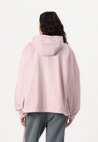 Lys rosa hettejakke med rutete mønster, elastiske cuffs og justerbar hem. Glatt stoff, avslappet passform, og bakfra.