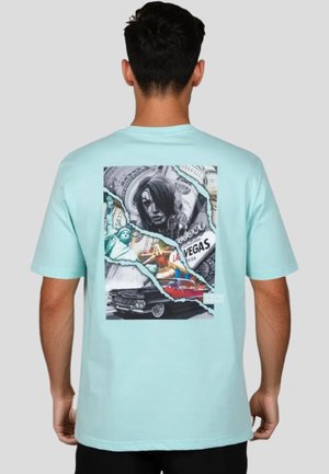Camisa de manga corta color verde menta con un colorido diseño gráfico en la parte posterior que incluye varias imágenes, como dinero y un coche clásico.