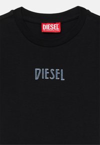 Schwarzes Baumwoll-T-Shirt mit Rundhalsausschnitt, das in der Mitte mit einem blauen, gestickten "DIESEL"-Logo verziert ist. Das Etikett trägt die Aufschrift "DIESEL FÜR ERFOLGREICHES LEBEN."