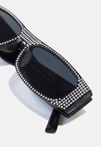 Ochelari de soare negri cu formă rectangulară, având o ramă împodobită cu cristale și lentile polarizate întunecate. Interior texturat și țevi negre elegante.