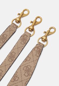 Sangle à motifs marron avec quincaillerie en métal doré et clips pivotants. Présente une texture lisse et un point de couture contrasté le long des bords.