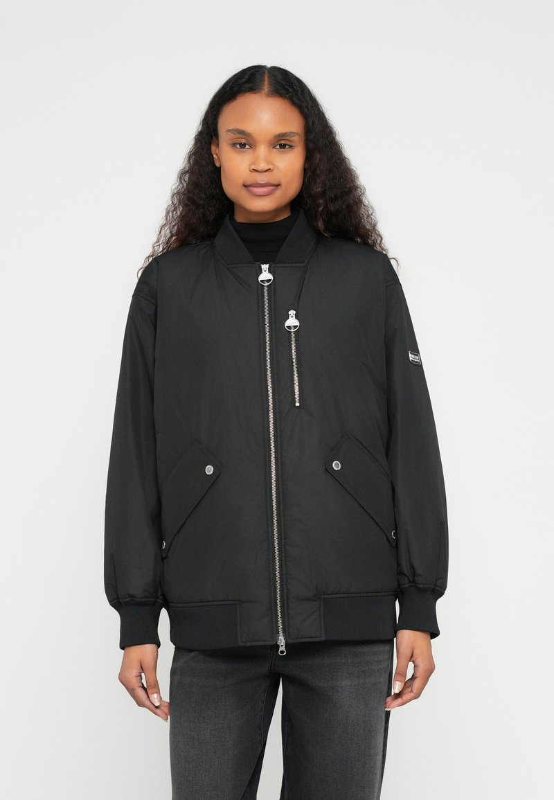 Μαύρο bomber μπουφάν με φερμουάρ μπροστά, δύο πλαϊνές τσέπες, ριμπ μανσέτες και ομοιόμορφη υφή. Διαθέτει λεπτομέρεια τσέπης με φερμουάρ στο στήθος.