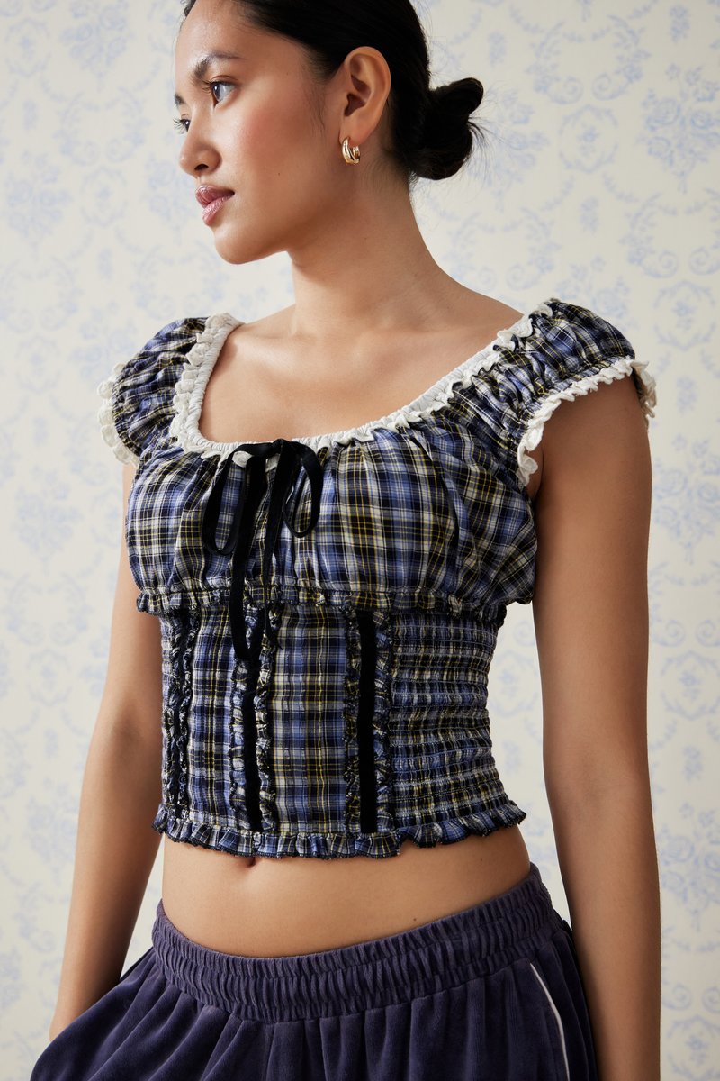 Plavi i žuti karo crop top s napuhanim rukavima, čipkastim obrubom, crnim ribon detaljima i smockiranim detaljima. Nosite ga s visokim tamnim donjim dijelom.