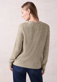 Ribattutko sweateri oliivinvihreänä, jossa on pyöreä kaula-aukko ja pitkät hihat. Pehmeä rakenne, rento malli ja suora helma.
