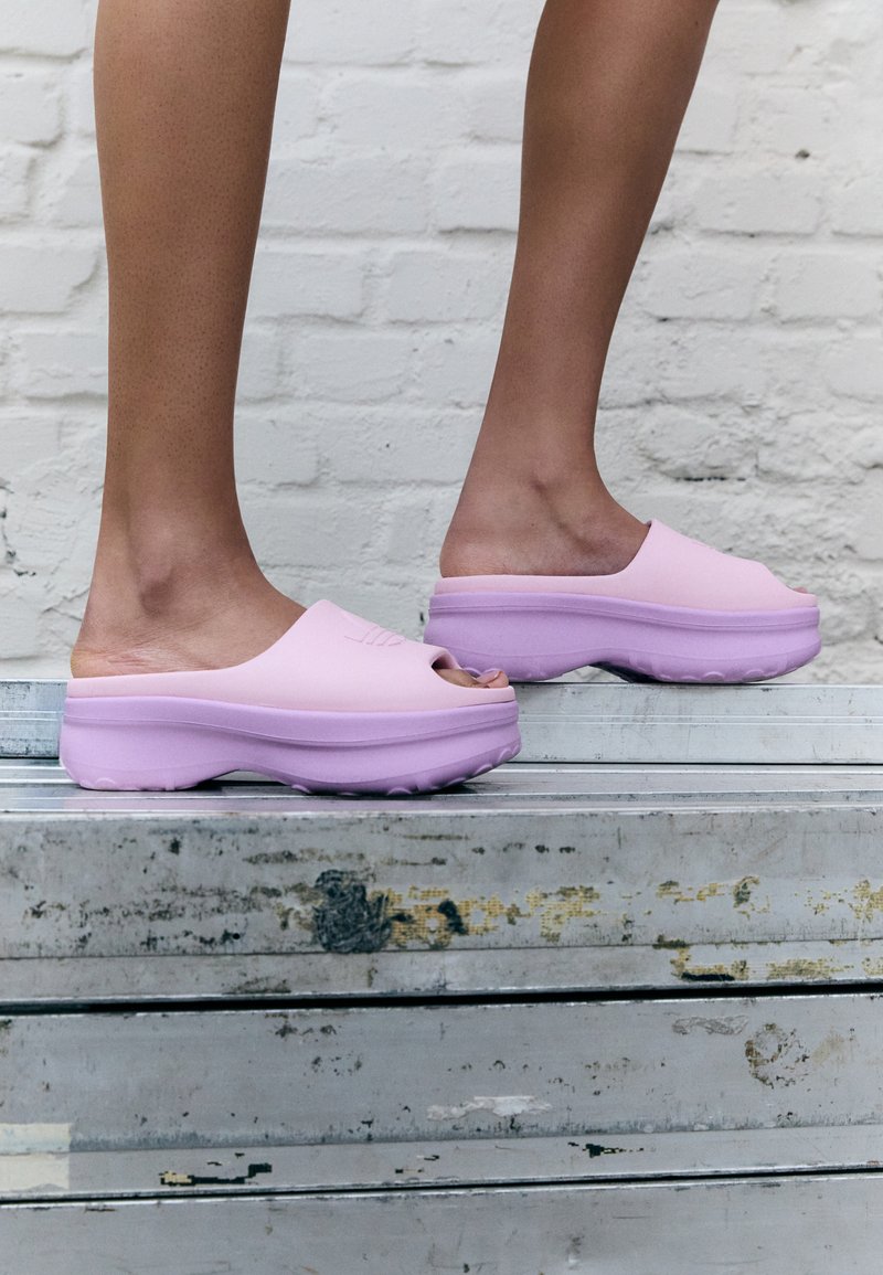 Purpurne oblikovane slip-on klompe z zaobljenim nosom in debelim podplatom. Teksturna guma z gladkim zaključkom in izrezljanim oblikovanjem.