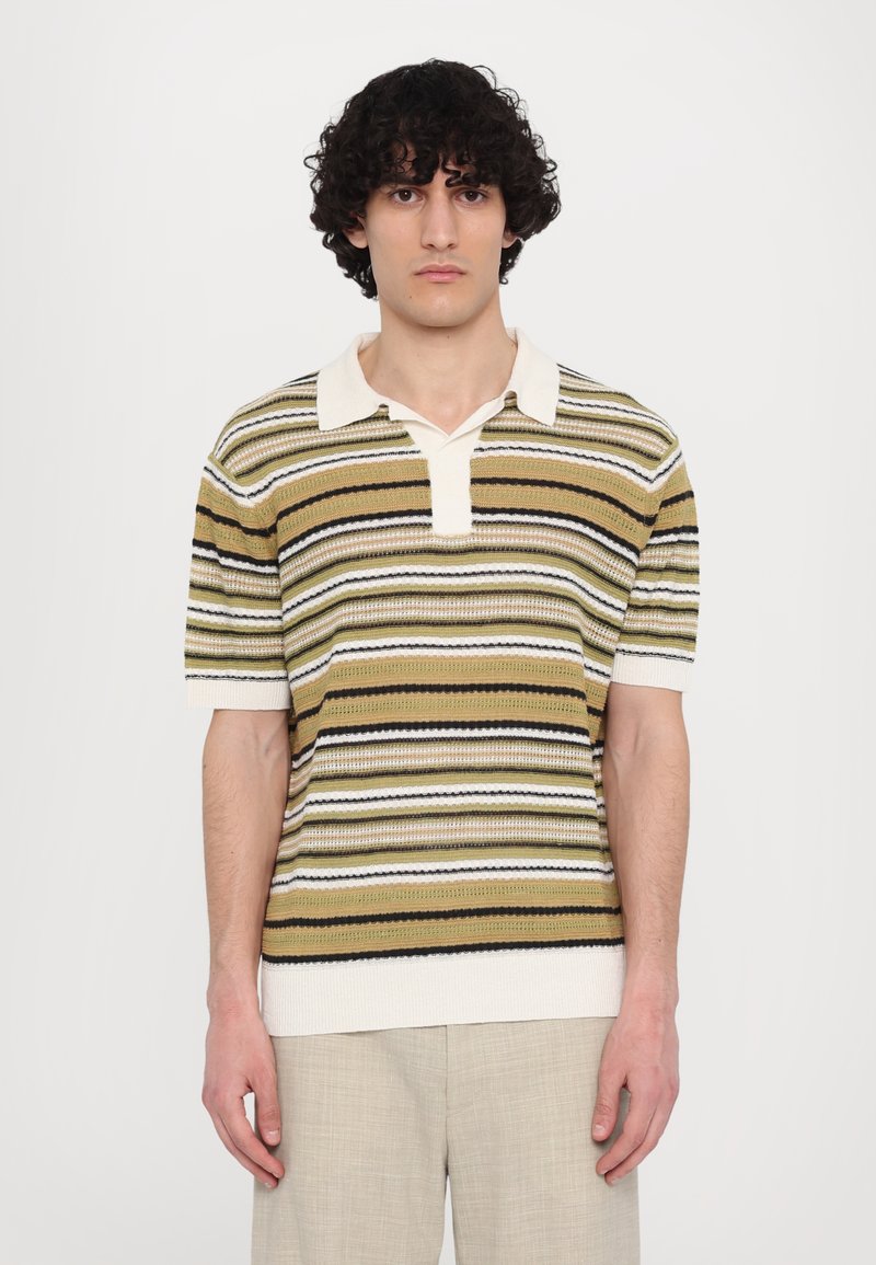 Polo shirt a maglia con maniche corte, caratterizzato da righe alternate in verde, beige, bianco e nero. Con colletto e una tessitura leggermente testurizzata.
