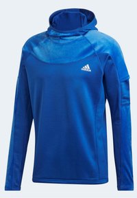 Felpa blu a maniche lunghe realizzata in tessuto morbido; presenta un colletto alto e pannelli a contrasto. Include il logo Adidas sul petto.