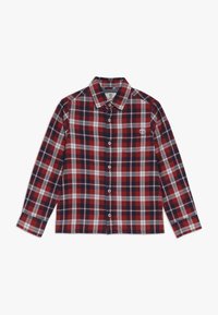 Koszula w czerwoną i granatową kratę zapinana na guziki, z białymi akcentami, długimi rękawami, kołnierzykiem oraz małym logo na kieszeni na piersi. Materiał bawełniany.