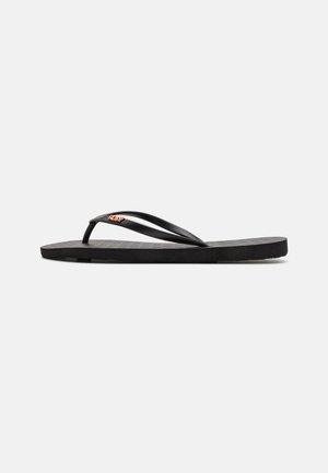 Svart flip-flop med platt sula, med tunna remmar och texturerad fotbädd. Litet logotypaccent på remmen. Enkel, minimal design.