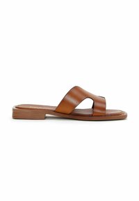 Sandale slide en cuir marron avec un petit talon empilé et de larges brides croisées sur une semelle plate.