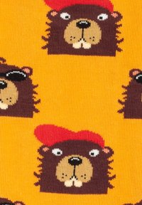 Calcetines coloridos con un patrón repetido de castores de dibujos animados con sombreros rojos sobre un fondo naranja. Hechos de un material suave y elástico.