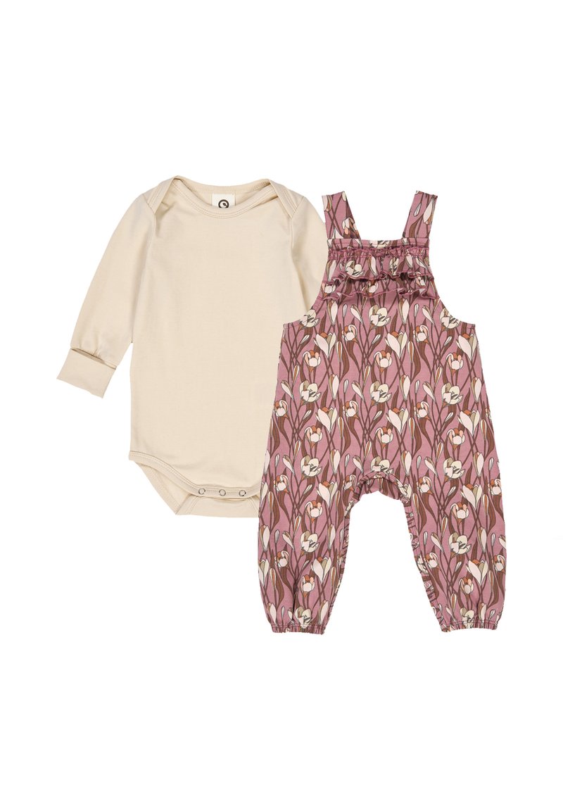 Twee-delig outfit: een beige langhalve mouw bodysuit met drukknoopsluiting, gecombineerd met roze overalls met bloemenpatroon en schouderbanden met ruches.