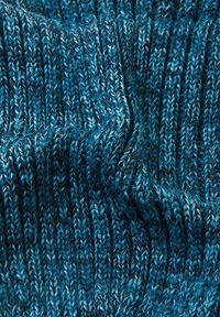Dzianina w różnych odcieniach niebieskiego, charakteryzująca się prążkowaną teksturą z wyraźnymi elastycznymi pasami. Materiał wygląda na miękki i przytulny.