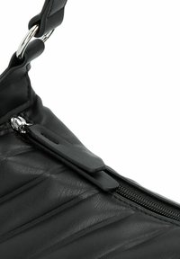 Zwarte leren handtas met een gestructureerde afwerking, voorzien van een rits en metalen hardware. Het ontwerp bevat plooien langs het lichaam.