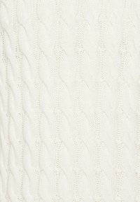 Weißer gestrickter Pullover mit einem strukturierten Zopfmuster mit erhabenen, verdrehten Designs. Weicher Stoff mit grobmaschigem Aussehen.