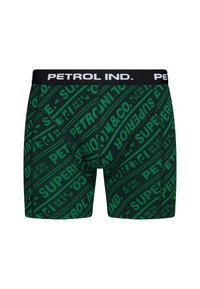 Grüne Boxershorts mit einem sich wiederholenden schwarzen Schriftzugdesign, das "PETROL IND." und "SUPERIOR" in Fettdruck zeigt. Elastischer Bund mit Logostickerei.