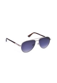 Lunettes de soleil style aviateur avec montures métalliques argentées et verres bleus dégradés foncés, branches à motifs écaille sur fond blanc.