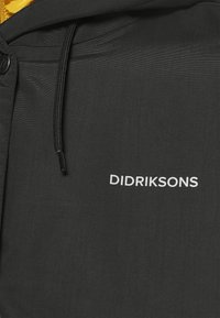 Veste noire à capuche en tissu léger. Dotée d'une fermeture éclair à l'avant et d'une capuche avec cordon de serrage. Logo "DIDRIKSONS" en blanc sur la poitrine.