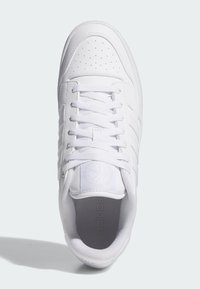 Biele športové topánky s hladkým koženým zvrškom, perforovanou špičkou a šnúrovaním. Majú polstrovaný interiér a textúrovanú gumovú podrážku.