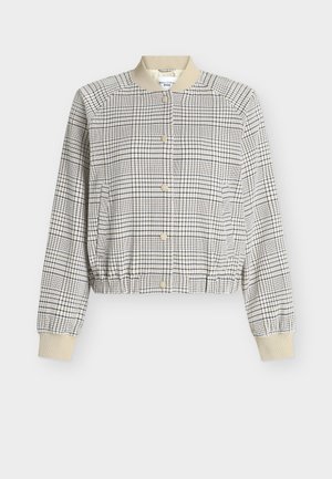 Įstrižai kirptas bomber stiliaus švarkelis smėlio spalvos su juodu tinklelio raštu. Su ribotais apykaklės ir rankogalių briaunomis bei priekyje susegimu sagomis. Tekstūruota medžiaga.