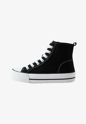 Black high-top canvas sneakers with white laces, rubber toe cap, and a white sole featuring a black stripe. Simple design with stitching details.