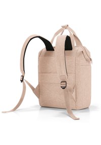 Mochila de tela rosa con correas ajustables, un asa en la parte superior y una superficie texturizada. Cuenta con un bolsillo con cremallera en un lado.