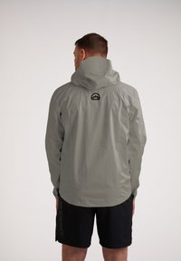 Giacca impermeabile grigio chiaro con cappuccio, dotata di un logo montano nero sul retro, texture liscia e vestibilità comoda.