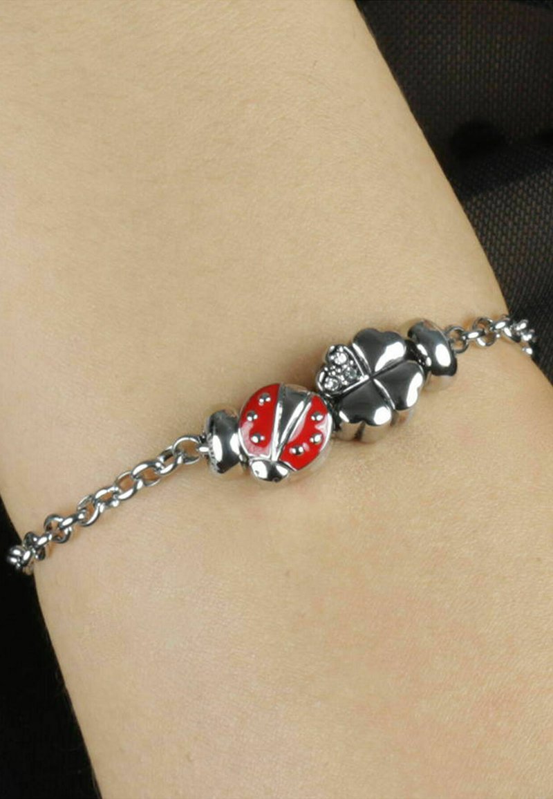 Bracciale in argento con ciondoli a forma di coccinella smaltata rossa e trifoglio in argento, decorato con piccoli cristalli trasparenti e accenti metallici lisci.