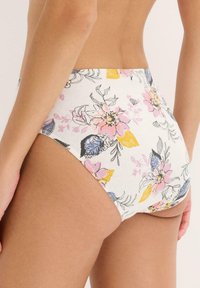 Costume bikini a vita alta in tessuto leggero con un motivo floreale che presenta fiori rosa, gialli e blu su uno sfondo bianco.
