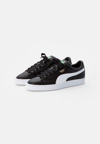 Sneaker in pelle nera con accenti bianchi. Punta rotonda, suola piatta, chiusura con lacci. Presenta il logo sul lato e sulla linguetta. Suola testurizzata.